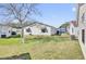 A spacious lawn area with a mature tree in the back with neighboring homes at 2606 Olivarez Way, The Villages, FL 32162
