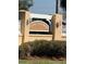 View of community entrance with sign for Village Alhambra and manicured bushes at 2606 Olivarez Way, The Villages, FL 32162