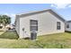 Exterior view of the home showing the siding, lawn, and air conditioning unit at 2606 Olivarez Way, The Villages, FL 32162