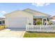 Single-story home featuring a well-kept lawn, driveway, and attached garage at 2606 Olivarez Way, The Villages, FL 32162