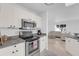 Bright kitchen featuring stainless steel appliances, stone countertops, and white cabinetry at 2606 Olivarez Way, The Villages, FL 32162