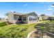 Exterior of home showcasing the back yard with well-maintained green grass and a sunroom addition at 2738 Privada Dr, The Villages, FL 32162