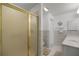 Bathroom showcasing a glass-enclosed shower stall, with a seashell accent and neutral-toned tile at 2738 Privada Dr, The Villages, FL 32162