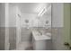 Bright bathroom featuring a vanity with white countertop, a large mirror and tiled walls with seashell decor at 2738 Privada Dr, The Villages, FL 32162