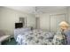 Bedroom showing floral bedding, dresser with TV, ceiling fan and natural light at 2738 Privada Dr, The Villages, FL 32162