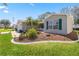 Landscaped front yard with green lawn, mulch beds, and charming exterior details at 2738 Privada Dr, The Villages, FL 32162