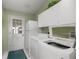 Functional laundry room complete with washer, dryer, cabinets and utility sink at 2738 Privada Dr, The Villages, FL 32162