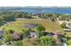 Wide angle aerial view showing the house surrounded by trees, lawns, and a pond at 2746 Park Royal Dr, Windermere, FL 34786