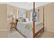 Cozy bedroom featuring a decorative four-poster bed, soft lighting, and natural light from the window at 2746 Park Royal Dr, Windermere, FL 34786