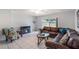 Bright living room features a modern tile flooring, leather sofa, and decorative fireplace at 3011 George Mason Ave # 3, Winter Park, FL 32792