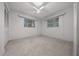 Simple bedroom design with white walls, two windows and a ceiling fan at 30713 George Dr, Tavares, FL 32778