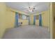 Spacious bedroom with blue curtains, fan, carpet and window air conditioner at 30713 George Dr, Tavares, FL 32778