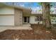 Front exterior shot of the single-story home with unique facade and attached garage and mature trees at 30713 George Dr, Tavares, FL 32778
