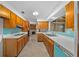 Kitchen area with wood cabinets, tile backsplash, and view to living area fireplace at 30713 George Dr, Tavares, FL 32778