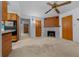 Living room with wood fireplace, ceiling fan, and convenient access to kitchen at 30713 George Dr, Tavares, FL 32778