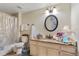 Bathroom featuring granite counters, wood flooring, decorative accents, and a black framed circular mirror at 3368 Parkchester Square Blvd # 104, Orlando, FL 32835