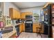 Compact kitchen features granite countertops, wood cabinetry, and black appliances at 3368 Parkchester Square Blvd # 104, Orlando, FL 32835