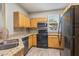 Kitchen featuring granite countertops, wood cabinetry, and black appliances at 3368 Parkchester Square Blvd # 104, Orlando, FL 32835