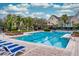 Community pool with lounge chairs, palm trees, and a volleyball net for residents to enjoy at 3368 Parkchester Square Blvd # 104, Orlando, FL 32835