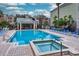 Community pool and hot tub with lounge chairs and nearby seating area for residents to enjoy at 3368 Parkchester Square Blvd # 104, Orlando, FL 32835