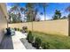 Private backyard with manicured lawn, barbecue grill, and a tall vinyl fence at 3390 Melissa Ln, The Villages, FL 32163