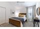 Cozy bedroom with wood bed frame, plush carpet, soft window light, and simple, stylish decor at 3390 Melissa Ln, The Villages, FL 32163