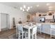 Open-concept dining area with modern chandelier and seating for four people at 3390 Melissa Ln, The Villages, FL 32163