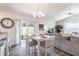Bright dining area with a white table, chandelier, and sliding glass doors to the outside at 3390 Melissa Ln, The Villages, FL 32163