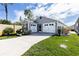 Attractive single-story home featuring a well-manicured lawn and a two-car garage at 3390 Melissa Ln, The Villages, FL 32163