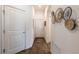 Bright hallway with wood floors, white doors and decorative wicker wall art; adds texture and visual interest at 3390 Melissa Ln, The Villages, FL 32163