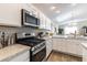 Clean kitchen with stainless steel oven range, white cabinets, countertop space, and natural light at 3390 Melissa Ln, The Villages, FL 32163