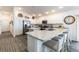 Spacious kitchen featuring white cabinetry, stainless steel appliances, and a long countertop with barstool seating at 3390 Melissa Ln, The Villages, FL 32163