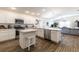 Bright kitchen features white cabinetry, stainless steel appliances, and wood flooring at 3390 Melissa Ln, The Villages, FL 32163