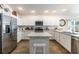 Bright kitchen with white cabinets, stainless steel appliances, center island, and stylish decor elements at 3390 Melissa Ln, The Villages, FL 32163