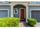 Close-up of a townhome's front door framed by an archway, a small window, and manicured landscaping at 384 Coral Beach Cir, Casselberry, FL 32707