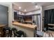 Modern kitchen featuring stainless steel appliances, dark cabinetry, and a breakfast bar overlooking the dining area at 384 Coral Beach Cir, Casselberry, FL 32707