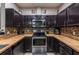 U-shaped kitchen featuring stainless steel appliances, dark wood cabinetry, and tile backsplash at 384 Coral Beach Cir, Casselberry, FL 32707