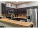 Well-equipped kitchen with stainless steel appliances, dark cabinets, and mosaic backsplash, creating a stylish cooking space at 384 Coral Beach Cir, Casselberry, FL 32707