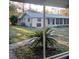 Exterior view of a charming home with a screened-in porch and lush landscaping at 43648 S Island Dr, Paisley, FL 32767