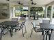 Covered outdoor patio area with tables and chairs, perfect for gatherings and socializing at 5509 Windsong Oak Dr, Leesburg, FL 34748