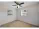 Bedroom with neutral carpet, ceiling fan, and two windows at 6213 Highland Ave, Leesburg, FL 34748