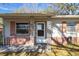 Inviting front porch with decorative iron supports and a glass-paneled door at 6213 Highland Ave, Leesburg, FL 34748