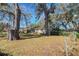 Property featuring a grassy front yard shaded by mature trees; American flag visible at 6213 Highland Ave, Leesburg, FL 34748