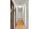 Hallway with wood laminate flooring and dark wood closet doors at 6213 Highland Ave, Leesburg, FL 34748