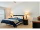Bedroom featuring a comfortable bed, bedside tables with lamps, and a dark dresser at 7163 Jerry Ave, The Villages, FL 34762