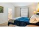 Bright bedroom features a comfortable bed, neutral walls, and view to the ensuite bathroom at 7163 Jerry Ave, The Villages, FL 34762