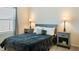 Cozy bedroom with neutral walls, soft lighting from bedside lamps, and comfortable grey-blue bedding at 7163 Jerry Ave, The Villages, FL 34762