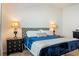 Elegant main bedroom features a tufted headboard, a blue comforter and matching bedside tables at 7163 Jerry Ave, The Villages, FL 34762