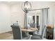 Dining area boasts a round table with gray upholstered chairs and a modern chandelier at 7163 Jerry Ave, The Villages, FL 34762
