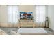 Bright living room features neutral colors, sheer curtains, and a wooden console table with modern decor at 7163 Jerry Ave, The Villages, FL 34762